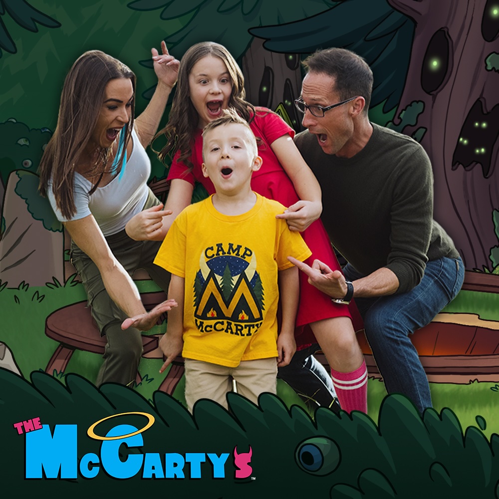 A family of four poses with excited, surprised expressions in front of a cartoon forest campsite. A young boy wearing a bright yellow "Camp McCarty" T-shirt stands in the center while the parents and the sister point toward him with animated reactions. The The McCarty's logo appears in the bottom left corner, with illustrated bushes framing the foreground.